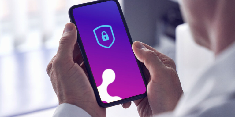 Man met smartphone in de hand, waar Koppeltaal op draait.